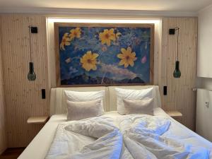 Un dormitorio con una cama con una pintura encima. en Mein Königreich en Garmisch-Partenkirchen
