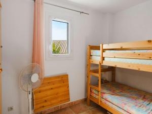 a bedroom with two bunk beds and a fan at Villa Gruissan, 3 pièces, 4 personnes - FR-1-409-31 in Gruissan