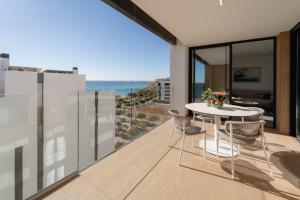 a balcony with a table and chairs and the ocean at Horizonte Line in Villajoyosa