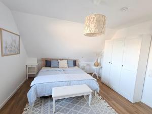 une chambre blanche avec un lit et une armoire blanche dans l'établissement Familienurlaub im Haus Seeglück, à Wangerland