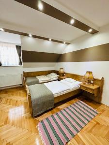 1 dormitorio con 2 camas y alfombra en Öreg Prés Butikhotel, en Mór