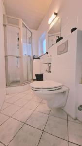 a white bathroom with a toilet and a shower at Ferienwohnung Best Apartments Leverkusen 1 in Leverkusen