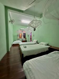 a room with three beds in a room at KFG Guesthouse in Thakhek