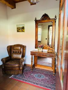 a chair and a mirror in a room at Öreg Prés Butikhotel in Mór