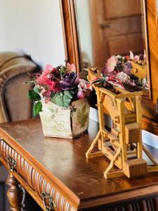 a table with a mirror and flowers on it at Öreg Prés Butikhotel in Mór