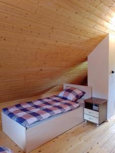 a bed in a room with a wooden ceiling at Siedlisko Sielska Dolina Nad Stawem luksusowy domek całoroczny z klimatyzacją 