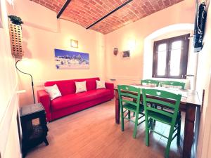 un soggiorno con divano rosso, tavolo e sedie di A Casa di Chicchi a Ovindoli