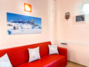 un divano rosso in una stanza con una foto sul muro di A Casa di Chicchi a Ovindoli