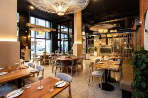 a restaurant with wooden tables and chairs and windows at Luxury Mountain View Aparthotel at The Tokyo- 12th Floor No Loadshedding in Cape Town