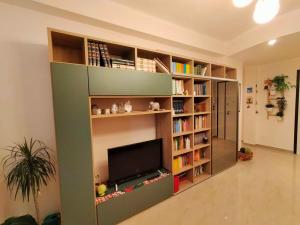 a large green book shelf with a television in it at A casa di Carola. Appartamento in centro dove sentirsi a casa in Molfetta