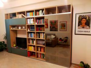 a living room with a book shelf filled with books at A casa di Carola. Appartamento in centro dove sentirsi a casa in Molfetta