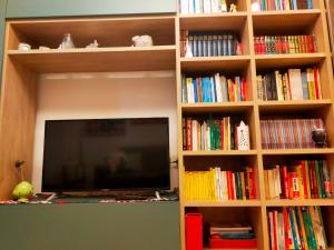 a book shelf with a flat screen tv and books at A casa di Carola. Appartamento in centro dove sentirsi a casa in Molfetta