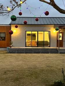 ein Haus mit Weihnachtsdekoration auf der Vorderseite in der Unterkunft ワンちゃんと泊まれるコテージ　西野納屋 in Kujukuri