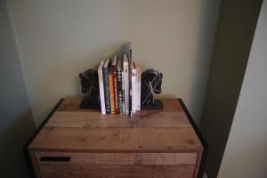 a bunch of books sitting on top of a wooden table at Julia's place in Hoylake