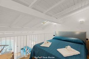Un dormitorio con una cama azul con toallas. en La Tana della Faina, TerreMarine, en Biassa