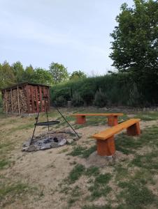 a picnic table and bench in a park at Siedlisko Sielska Dolina Nad Stawem luksusowy domek całoroczny z klimatyzacją 