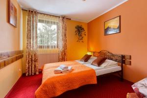 a bedroom with a bed with two towels on it at Willa Bartek in Zakopane