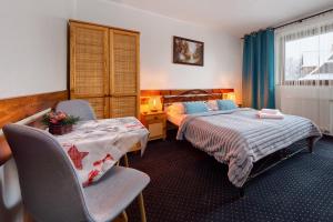 um quarto com 2 camas, uma mesa e cadeiras em Willa Bartek em Zakopane