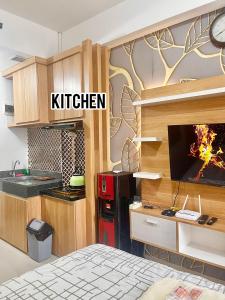 a kitchen with a tv on a wall at apartemen transpark cibubur by trend property in Kalimanggis