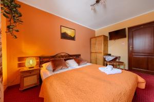 a bedroom with a large bed with two towels on it at Willa Bartek in Zakopane
