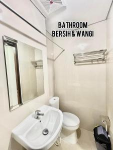 ein Badezimmer mit einem Waschbecken, einem WC und einem Spiegel in der Unterkunft apartemen transpark cibubur by trend property in Kalimanggis
