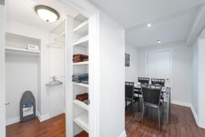 een kamer met witte planken en een tafel en stoelen bij Cozy Lovely Ravine facing Suite. in Mississauga