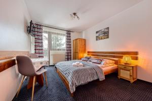 a bedroom with a bed and a desk and a bed sidx sidx sidx at Willa Bartek in Zakopane