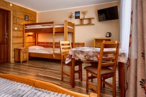 a bedroom with bunk beds and a table and chairs at Willa Bartek in Zakopane