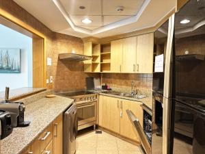 una cocina con armarios de madera y electrodomésticos de acero inoxidable en Seaside Serenity Residence Elegant 1BR Escape in Palm Jumeirah by La Buena vida holiday homes en Dubái