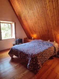 um quarto com uma cama e um tecto em madeira em Chalet Edelweiss Marsia-Tagliacozzo 1500mt em Marsia