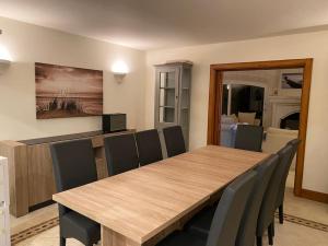 uma sala de jantar com uma mesa de madeira e cadeiras em Villa vue mer à côté de Cannes dans l'Esterel ! em LʼÉglise