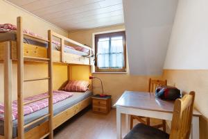 a room with bunk beds and a table and a desk at Prinzbachhof in Mühlenbach