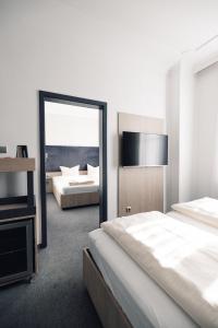 Habitación de hotel con 2 camas y espejo en N9 Hotels, en Núremberg