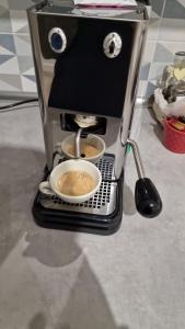 una cafetera con una taza en un estante en Appartamento Daisy - Parma, en Parma