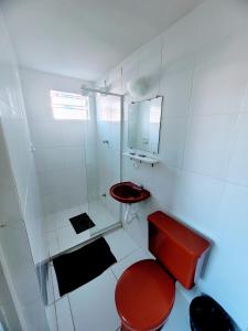 La salle de bains est pourvue de toilettes rouges et d'un lavabo. dans l'établissement Guarujá Praia Hotel Econômico, à Guarujá