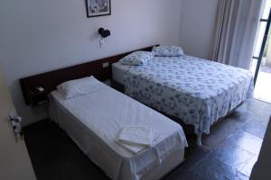 - une chambre avec 2 lits et une fenêtre dans l'établissement Pousada do Rio Corrente, à Santa Maria da Vitória
