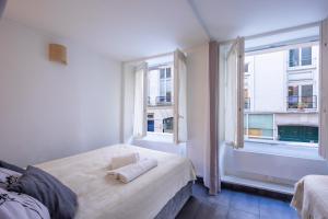 um quarto com 2 camas e 2 janelas em LOUVRE-MONTORGEUIL PARIS HISTORICAL CENTER em Paris
