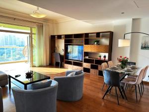 un soggiorno con tavolo, sedie e TV di Seaside Serenity Residence Elegant 1BR Escape in Palm Jumeirah by La Buena vida holiday homes a Dubai