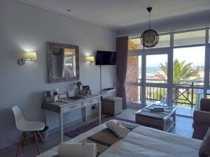 a bedroom with a bed and a desk with a sink and a window at Brookes Hill Suites 238 in Port Elizabeth