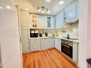 a kitchen with white cabinets and a wooden floor at Central Cozy Home Ferragudo in Ferragudo +28 photos