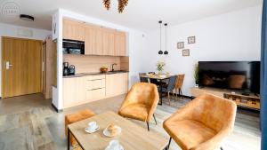 a kitchen and living room with a table and chairs at Apartamenty Good Time - Górna Resort in Szklarska Poręba