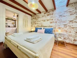 費拉古杜的住宿－Central Cozy Home Ferragudo，一间卧室设有一张带砖墙的大床
