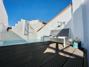a bench sitting on top of a wooden deck at Central Cozy Home Ferragudo in Ferragudo