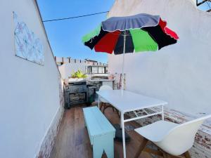 a table with a colorful umbrella in a room at Central Cozy Home Ferragudo in Ferragudo