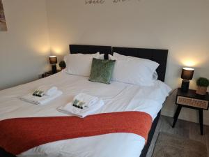 um quarto com uma cama com duas toalhas em Lovely 2-Bed Apartment in Cheltenham Spa em Cheltenham