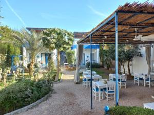 a patio with tables and chairs under a pavilion at Villa Kaslan Apartments in Luxor