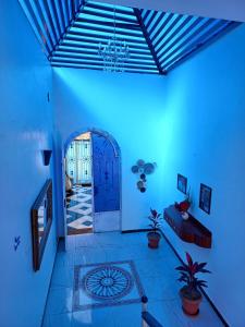 a blue room with a door and some plants at Villa Kaslan Apartments in Luxor