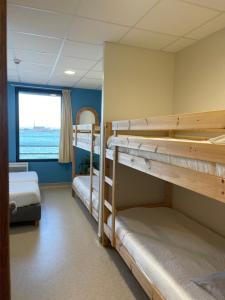 a room with two bunk beds and a window at CLLCM - Club Leo Lagrange de Camaret-sur-Mer in Camaret-sur-Mer