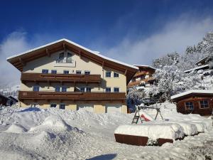 ein großes Gebäude mit Schnee vor der Tür in der Unterkunft Appartement Christine in Brixen im Thale