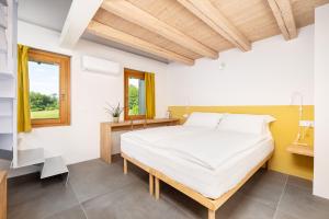 een slaapkamer met een groot wit bed en een raam bij B&B Le Zucche in Belluno